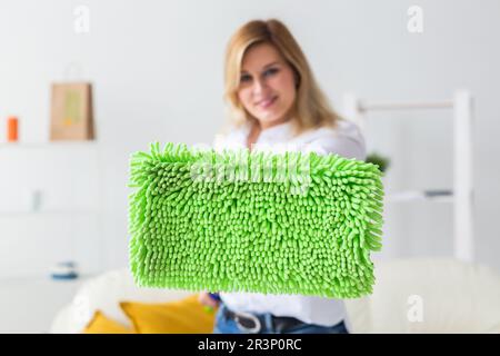 Donna sorridente casalinga millenaria con spazzolone per lavaggi pavimento ama la pulizia in interni minimalisti. Servizi di pulizia domestica e lavori domestici Foto Stock