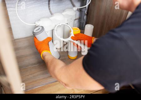 L'idraulico installa o cambia il filtro dell'acqua. Filtro acqua di ricambio Foto Stock