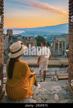 Taormina Sicilia, coppia che guarda il tramonto alle rovine dell'antico Teatro Greco Taormina, Sicilia Foto Stock