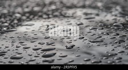 Sfondo con gocce d'acqua su una superficie scura, messa a fuoco selettiva, sfondo sfocato. Il concetto di protezione contro l'umidità e la pioggia di superfici e accoppiamenti Foto Stock