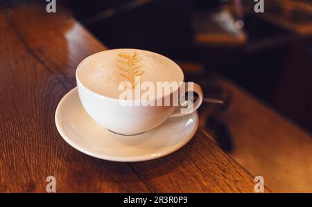 Cappuccino caffè primo piano nella preparazione sopra il tavolo di legno Foto Stock