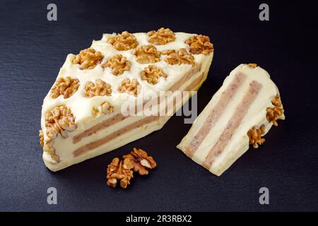 Tradizionale formaggio francese morbido con noci offerto come primo piano su una tavola nera Foto Stock