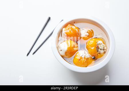 Piccoli peperoncini di ciliegia gialli sott'aceto farciti con panna o ricotta. Snack delizioso Foto Stock