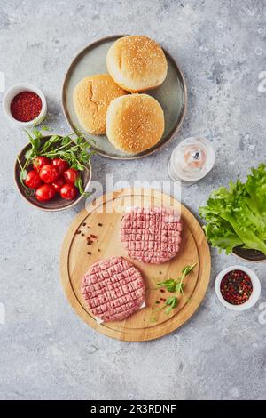 Cotolette di bistecca di vitello crudo al Burger su tagliere in legno Foto Stock