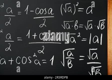 Diverse formule matematiche scritte con il gesso sulla lavagna Foto Stock