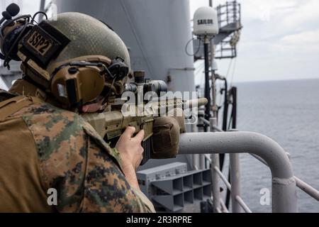 NEGLI STATI UNITI Marine con la 26th Marine Expeditionary Unit, si affaccia su una barca nemica simulata durante una parte di transito stretto simulata dell'addestramento composito Unit Exercise (C2X), Oceano Atlantico, 21 maggio 2023. Il transito stretto ha simulato la nave d'assalto anfibio di classe Wasp USS Bataan (LHD 5), la nave di sbarco portuale di classe Harpers Ferry USS carter Hall (LSD 50) e la nave portuale di trasporto anfibio di classe San Antonio USS Mesa Verde (LPD 19) che entravano in contatto, ricevevano e restituiva il fuoco nemico da piccole imbarcazioni durante la formazione. C2X è l'ultimo periodo in mare del programma di formazione pre-implementazione fo Foto Stock