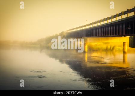 Exploring the Rural Hills of Berwick (SW of Dunedin) at sunrise on a freezing frosty day with low mist and fog over the river flowing through the vall Foto Stock