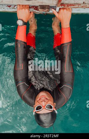 Ritratto del nuotatore triatleta che indossa una muta durante l'allenamento Foto Stock