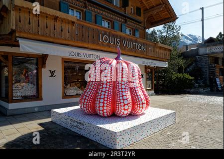 Statua di zucca rossa e bianca all'esterno di un negozio Louis Vuitton nella città svizzera di Gstaad. Yayoi Kusama installazione artistica in strada. Foto Stock