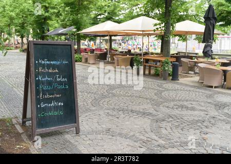 Lavagna con le offerte attuali come la colazione, torta, pizza, di fronte a un caffè a Berlino Foto Stock