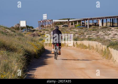 Ciclista di fronte al chiringuito es Ministre, Parco Naturale Ses Salines dEivissa i Formentera, Formentera, Isole Pitiusas, Comunità Baleari, Spagna. Foto Stock