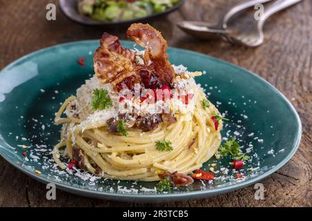 Spaghetti alla carbonara con insalata su legno Foto Stock