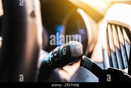 Interruttore di comando tergicristalli per auto. Primo piano della leva di comando dei tergicristalli e dei lavavetri di un'auto Foto Stock