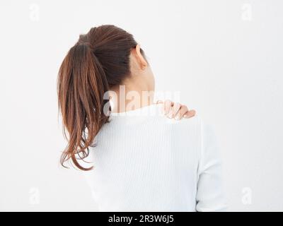 Donna asiatica che soffre di spalle rigide Foto Stock