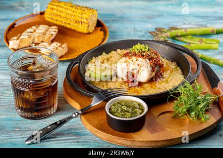 Un pezzo di pesce con salsa su un letto di riso o orzo, grigliato con lime. Piatti originali dello chef del ristorante Foto Stock