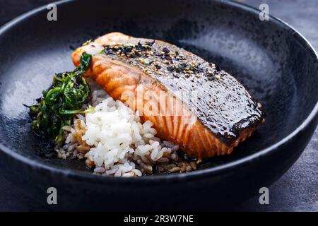 Tradizionale filetto di teriyaki di salmone giapponese con riso koshihihikari e spinaci in foglia fritti servito da primo piano in un desi nordico Foto Stock