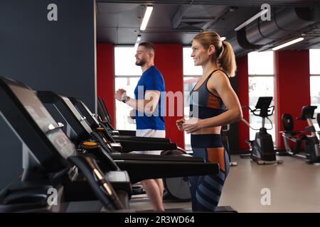 Bella coppia di allenamento su tapis roulant in palestra Foto Stock