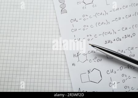 Fogli di carta con diverse formule chimiche e penna, vista dall'alto. Spazio per il testo Foto Stock