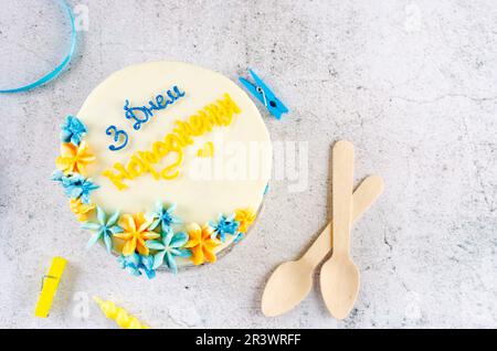 Torta bento alla moda con un'iscrizione blu-gialla in ucraino "buon compleanno" su sfondo chiaro. Torta di compleanno, torta Bento per due Ukrai Foto Stock