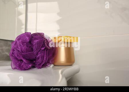 Soffio doccia viola e prodotti cosmetici sul lavandino in bagno, spazio per il testo Foto Stock