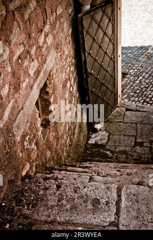 vecchia porta medievale in metallo alla fine di una scala in pietra Foto Stock