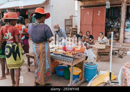 Venditore di cibo di strada sulla strada principale di Miandrivazo. In Madagascar, la gente di solito mangia per strada. Foto Stock