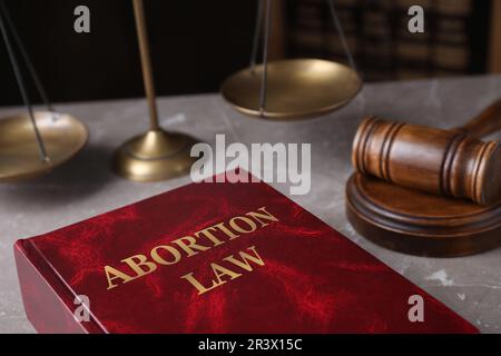 Abortire Law book, scale di giustizia e gavel su tavola di marmo marrone Foto Stock