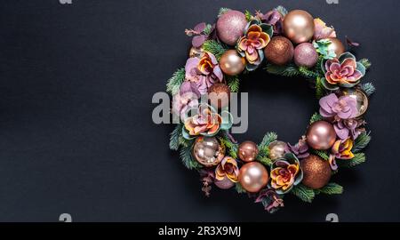 Bella decorazione wreath di Natale su sfondo nero. giacitura piatta con spazio di copia Foto Stock