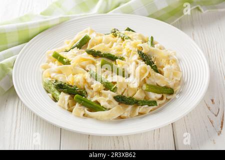 Asparagi Pasta con scorza di limone e parmigiano sul piatto del tavolo di legno. Orizzontale Foto Stock