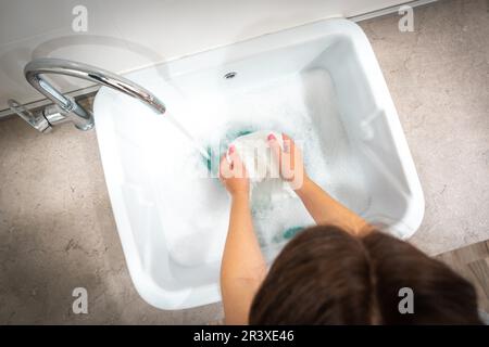 Lavanderia con lavaggio donna vestiti di bianco Foto Stock