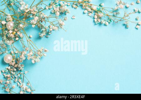 Composizione floreale con piccoli fiori di Gypsofila su sfondo blu pastello. Disposizione piatta, vista dall'alto, spazio di copia Foto Stock