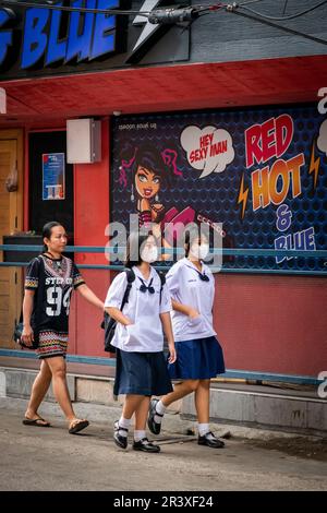 Le giovani ragazze della scuola thailandese fanno il loro senso lungo la strada trafficata di Soi Buakhao in Pattaya Thailandia. Foto Stock