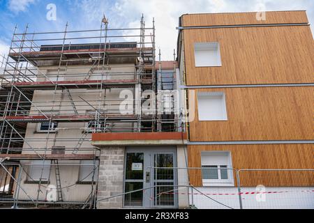 Riabilitazione termica di edifici di appartamenti. Ristrutturazione di facciate con installazione di coibentazioni e rivestimenti. Isolamento parete esterna, energ Foto Stock