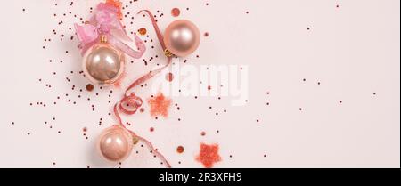 Panorama della composizione natalizia. Palline di Natale, decorazioni rosa e dorate su sfondo rosa. Piano di giacitura, vista dall'alto, centro di copiatura Foto Stock