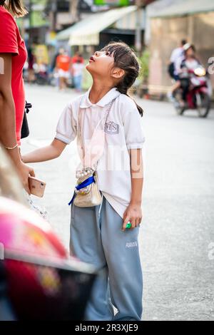 Una giovane ragazza tailandese attende un giro a casa dopo la scuola nella città di Pattaya Thailandia. Foto Stock