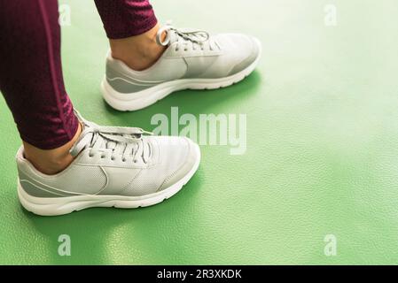 Vista ravvicinata della donna di gambe indossando scarpe da ginnastica in palestra con spazio di copia Foto Stock