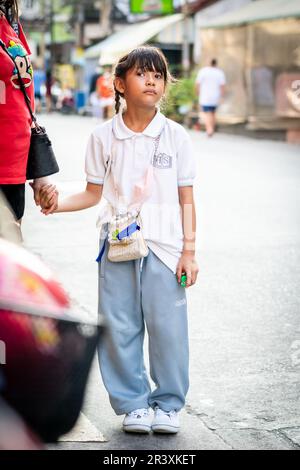 Una giovane ragazza tailandese attende un giro a casa dopo la scuola nella città di Pattaya Thailandia. Foto Stock