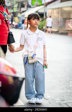 Una giovane ragazza tailandese attende un giro a casa dopo la scuola nella città di Pattaya Thailandia. Foto Stock