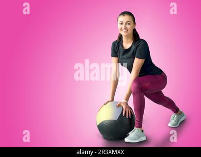 Donna in palestra rilassante con palla medica Foto Stock