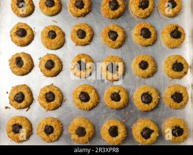 Biscotti al formaggio con ripieno di cioccolato, biscotti al forno con effetto thumbprint sulla padella di alluminio Foto Stock