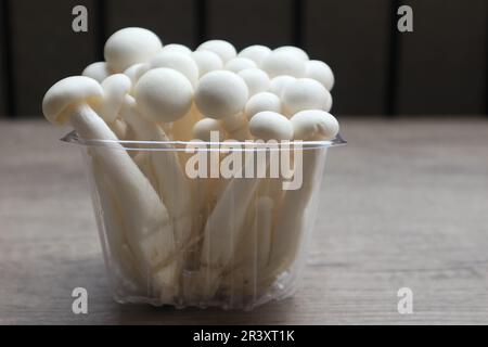 Funghi bianchi di faggio, funghi Shimeji, funghi commestibili sul tavolo di legno Foto Stock