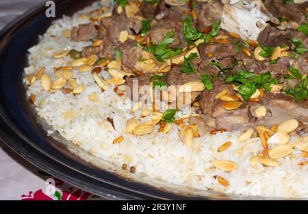 Carne di cammello con riso tradizionale arabo piatto principale ristorante pranzo servito con mandorle e semi di pino. Foto Stock