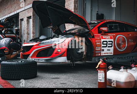 Meccanico che lavora su una Ferrari GT3 in garage Foto Stock