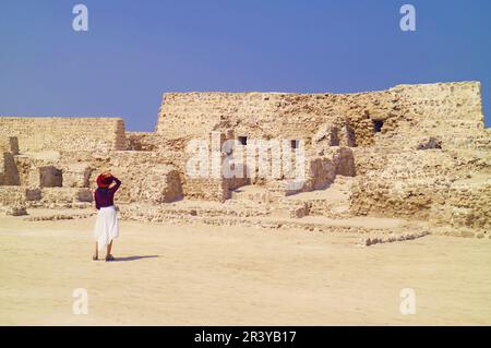 I visitatori sono rimasti impressionati dai resti di Qall'at al-Bahrain, patrimonio dell'umanità dell'UNESCO a Manama del Bahrain Foto Stock