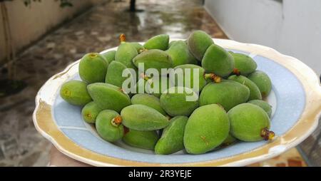 Primo piano di mandorle verdi fresche su un piatto Foto Stock