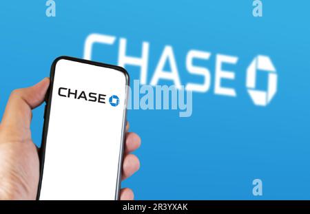 New York, Stati Uniti, marzo 2023: Mano che tiene un telefono con il logo Chase visualizzato sullo schermo. JPMorgan Chase Bank è una banca nazionale americana. A scopo illustrativo Foto Stock