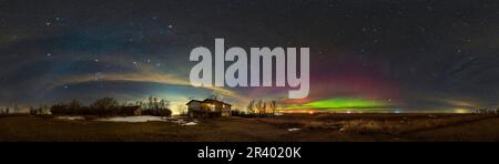 Un panorama a 360 gradi del tardo inverno e del cielo primaverile con un arco di aurora, Alberta meridionale, Canada. Foto Stock