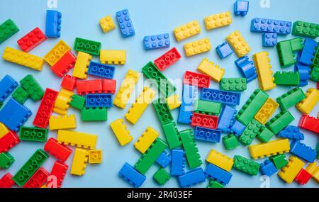 Cubi di plastica multicolore di un designer per bambini su sfondo blu, vista dall'alto Foto Stock