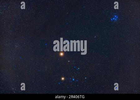 Marte rossastro brillante sopra il gruppo di stelle di Hyades, con Pleiades in alto a destra. Foto Stock