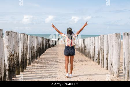 Donne felici con mani in su sulla spiaggia durante le vacanze, pali sulla spiaggia Domburg Zeeland Paesi Bassi Foto Stock